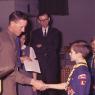 David gets a cub scout handshake as dad & mom look on